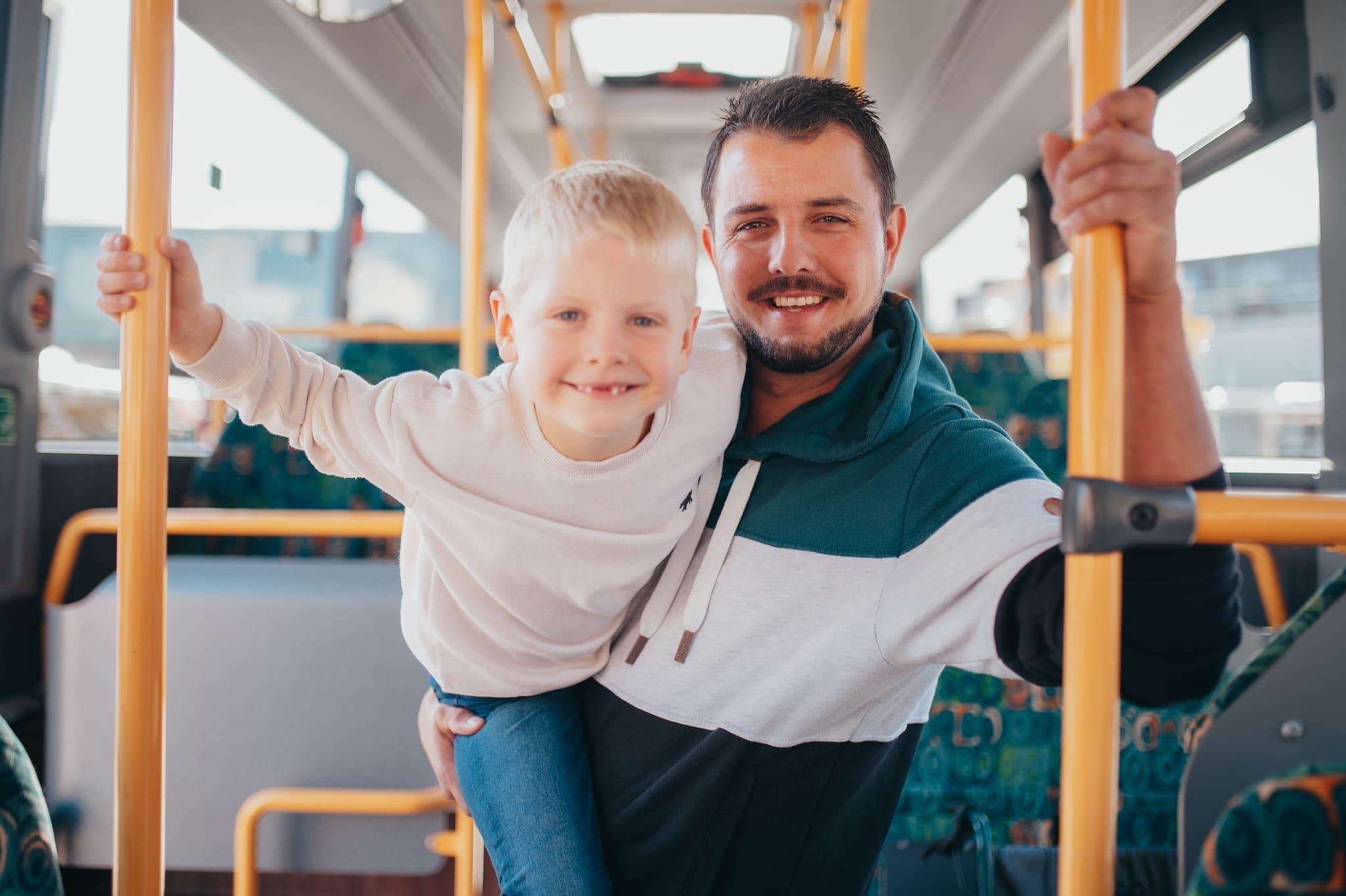 Vater und Kind steigen über die abgesenkte Einstiegsrampe in den Bus ein