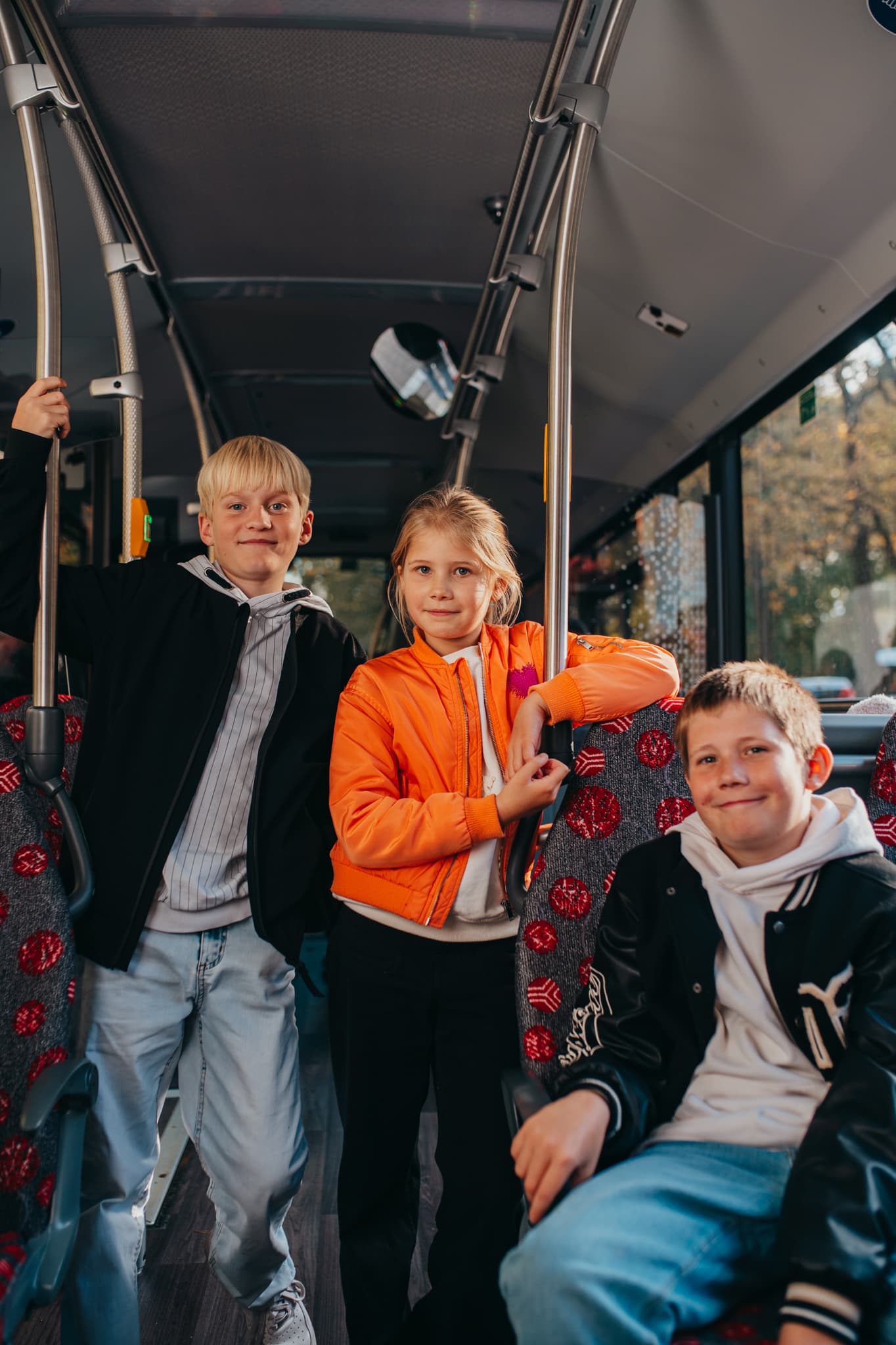 Gruppe von Schülerinnen und Schülern wartet an der Haltestelle auf den Bus