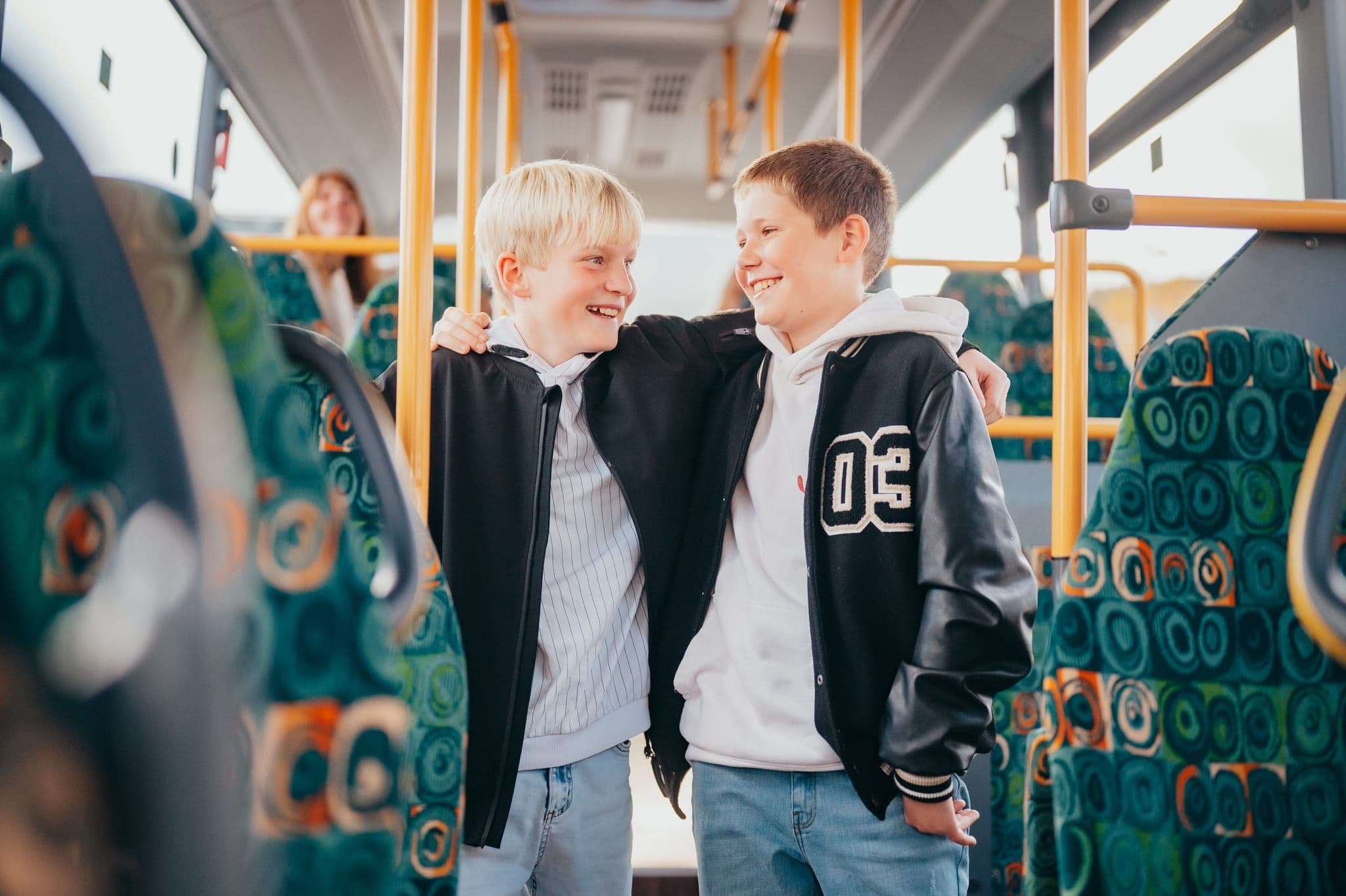 Zwei Schulkinder sitzen nebeneinander im Bus